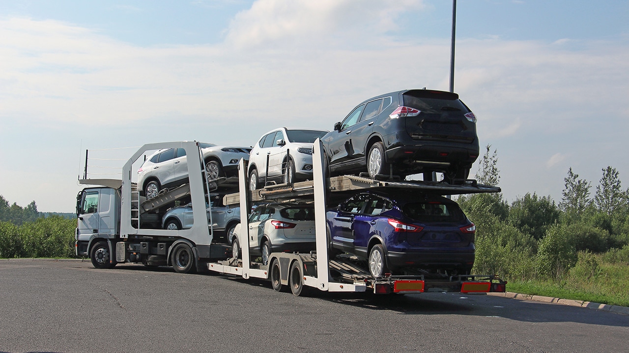You can get car shipping quotes online to help you get your car shipped in an auto transporter that carries cars down a highway like this one pictured.